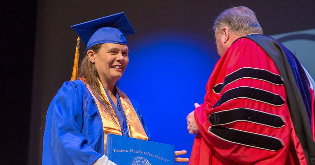 EFSC graduate Sarah Leon being given her degree from EFSC president Dr. Richey. The image symbolizes completing your education.