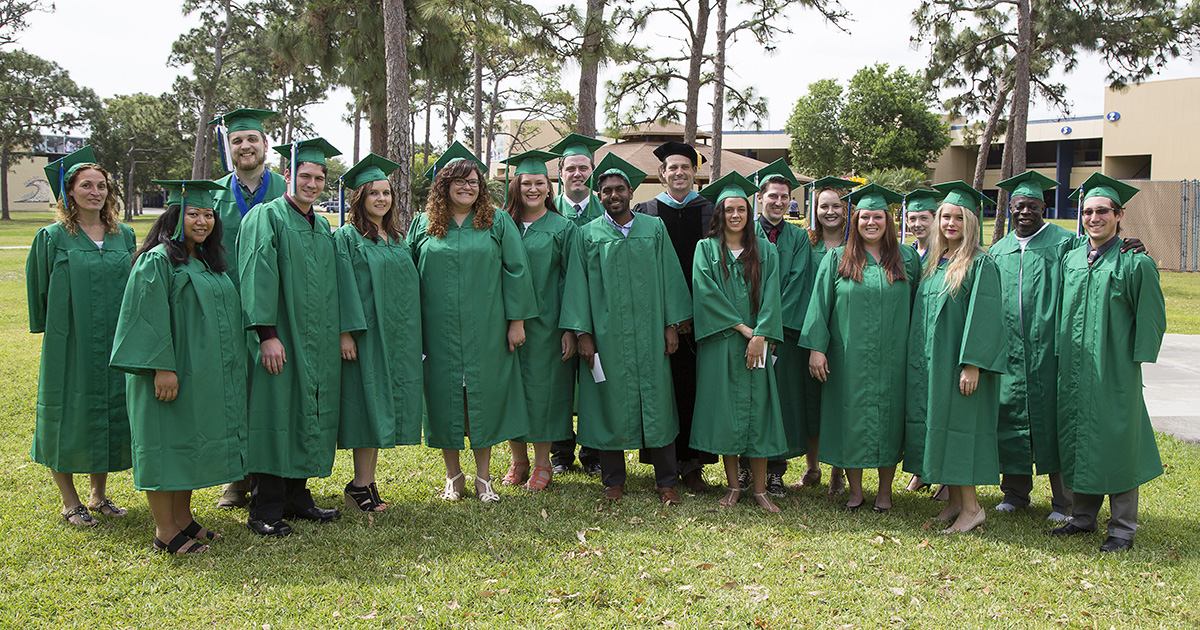 A large group of EFSC Bacherlor graduates in green robes. One of the graduates is Joey Hilde, representing EFSC Alum Success.