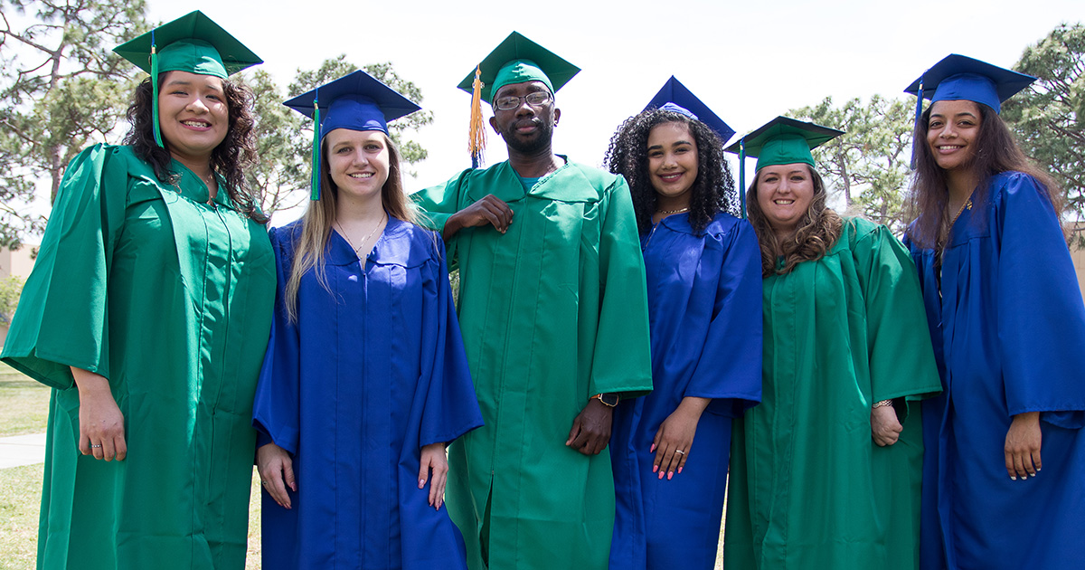 A group of diverse Eastern Florida State College graduates wearing blue and green robes, representing the EFSC Alumni Association.