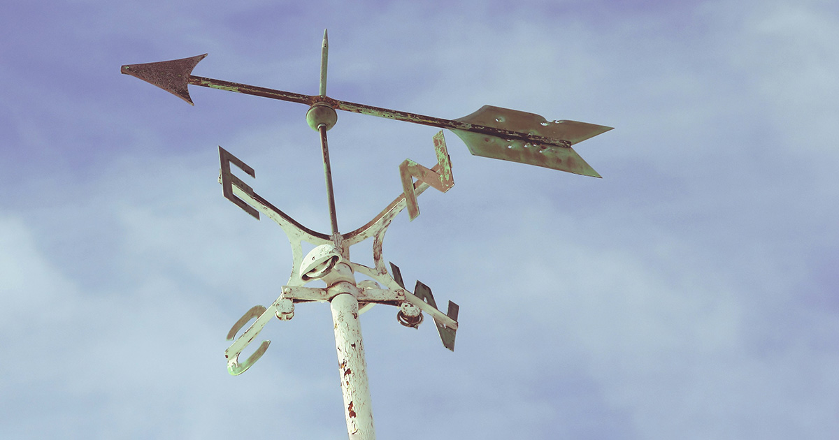 A rusty white weathervane with a blue sky in the background. The image represents the FAFSA success guide pointing students in the right direction.
