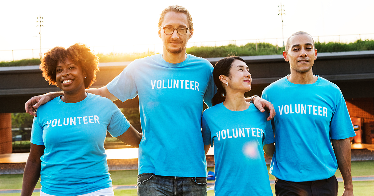 A diverse group of volunteers wearing blue shirts that say "volunteer". The image represents the ability to find passion through volunteering.