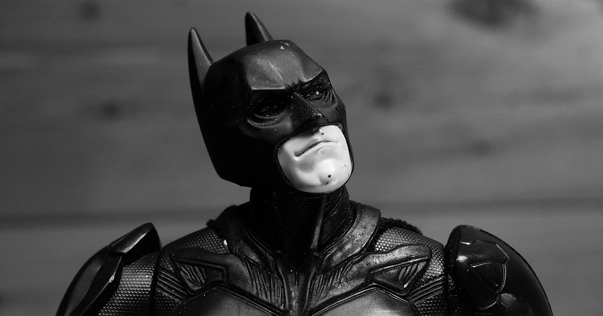A batman action figure with its head tilted up. It evokes thoughts of Batman finding a mentor in Alfred.