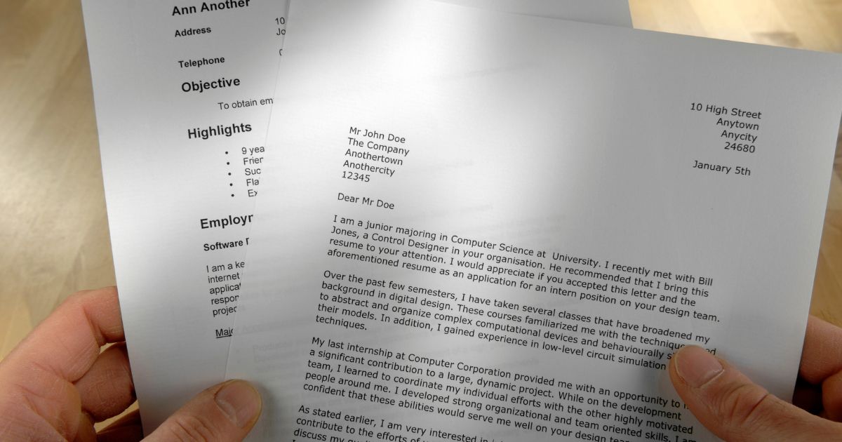 Male hands holding the upper part of a cover letter written in business letter template along with a copy of a resume. It evokes the question of how to write a cover letter.