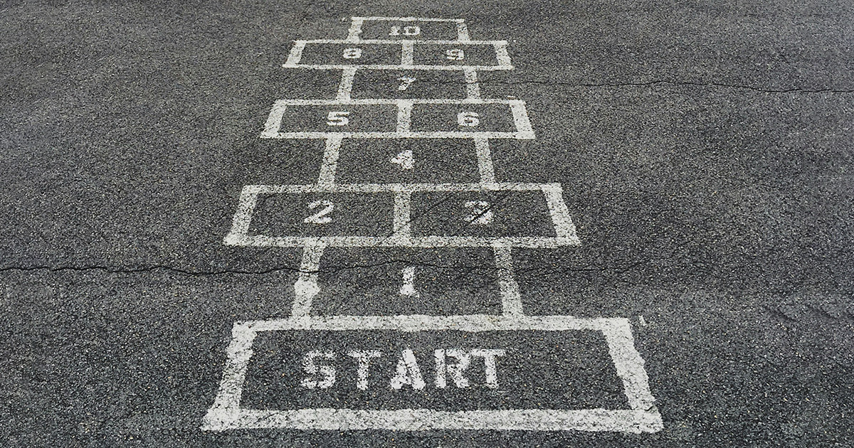 A hopscotch game drawn in white chalk on asphalt. It serves as a metaphor for productive online learning.