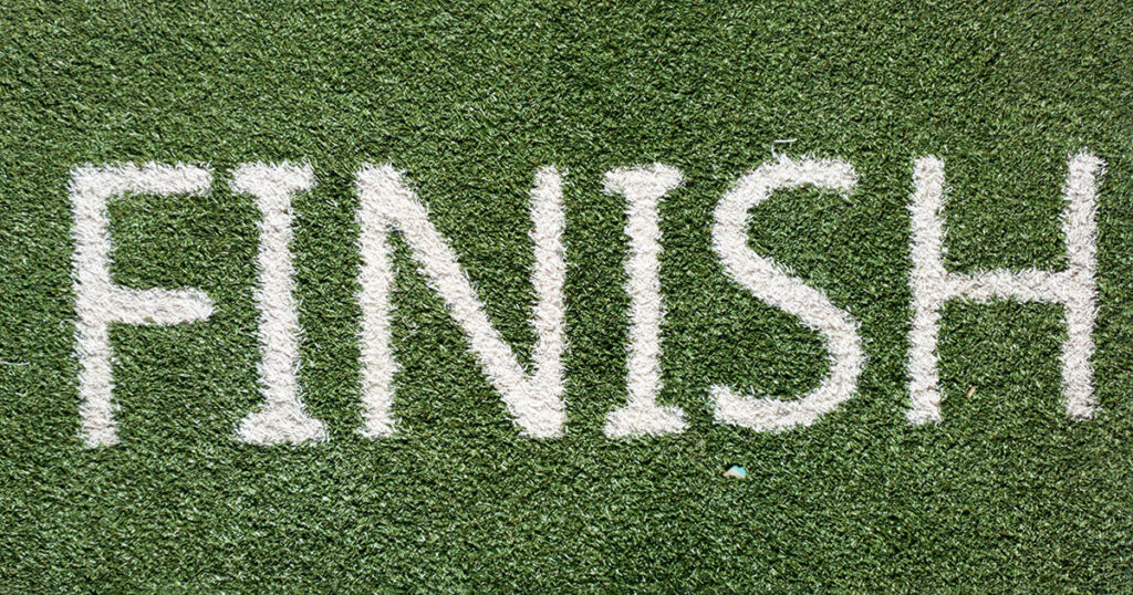 "FINISH" written in white paint on green grass, symbolizing returning college students.