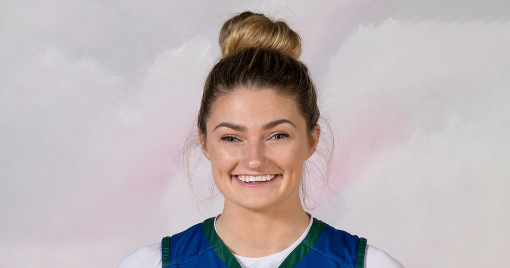 Sierra Votaw - a portrait of a young white woman with blond hair in a bun smiling.