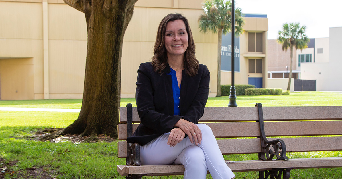 Dr. Laura Sidoran sitting on a bench at the EFSC Melbourne Campus, serving as a Student Success Advocate.