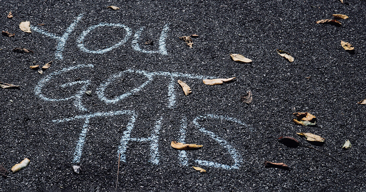 "You got this" written in chalk on an asphalt sidewalk. The message embodies various tips for boosting confidence.