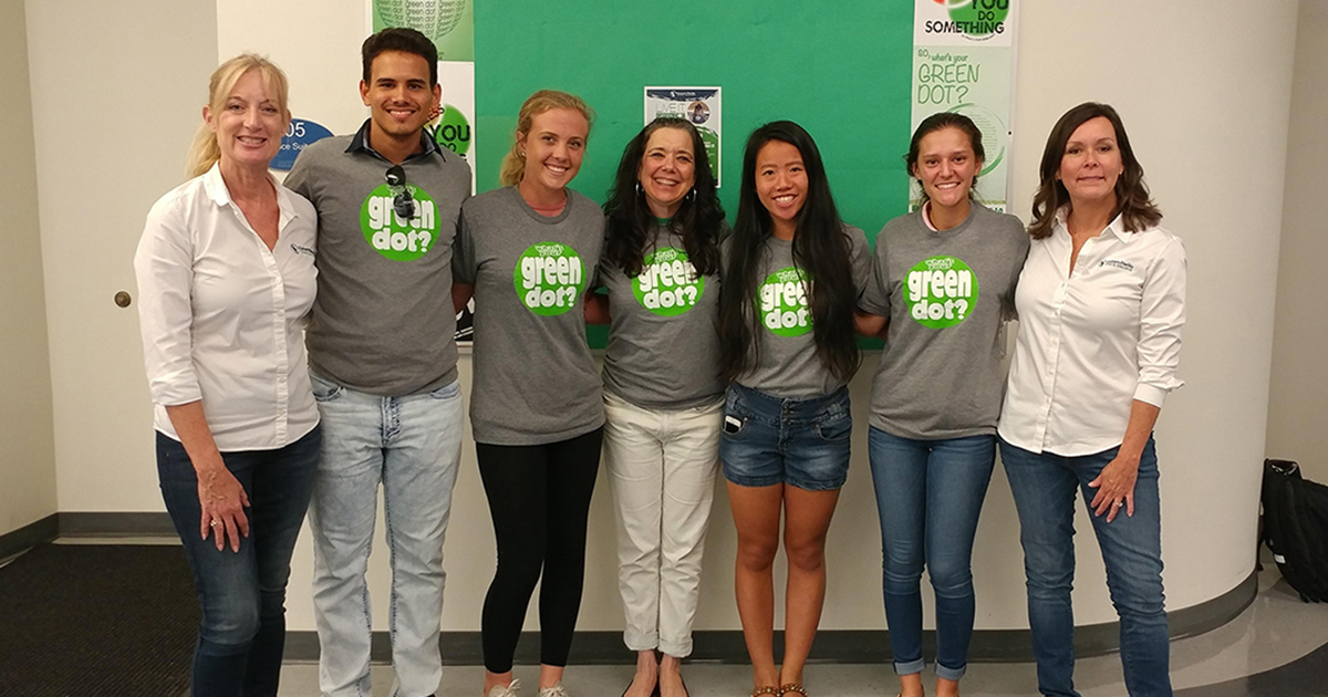 EFSC employees and students posing for a photo while wearing green dot t-shirts. The image poses the question "What's Green Dot?"
