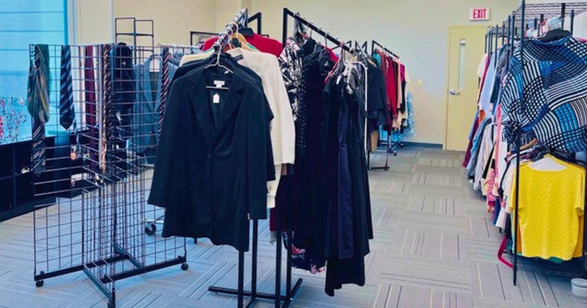 A photo of the Cocoa EFSC Titan2Titan Clothing Closet, featuring professional jackets, blazes, dress shirts, and tie tactfully arranged on circular and longways clothing racks.