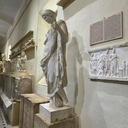 An internal museum, focusing on a white statue of a woman with a downward gaze