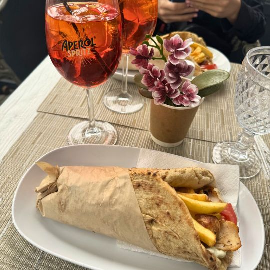 Greek food (a gyro) with fruit drinks in a glass