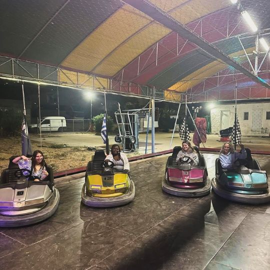 Four students riding bumper cars at a small amusement park