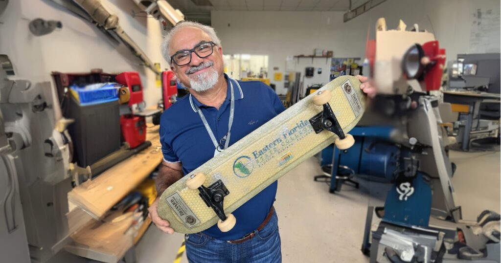 Professor Meer Almeer holds a skateboard crafted from composites in the engineering lab