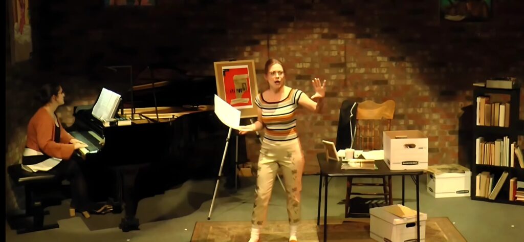 A scene from the A Zine Opera, in which Keri Lee Pierson stands dramatically with outspread arm in the middle of a study, singing an opera number