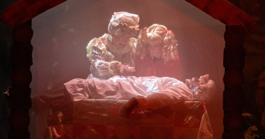 A scene depicting Little Red Riding Hood and the Wolf in Grandma's Clothing